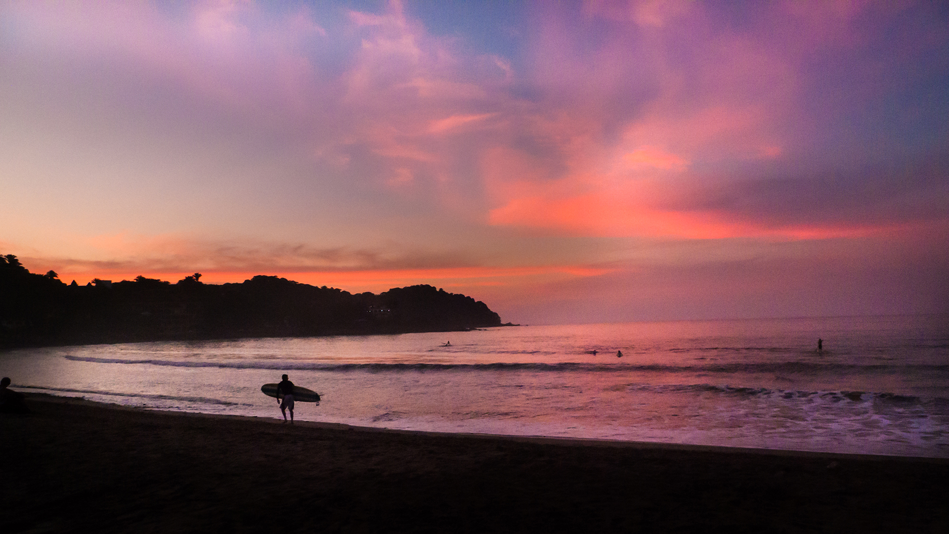 silhoutted surfer in front of sayulita sunset